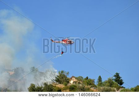 August 21 2016-Monti Prenestini-Castel San Peter- Roma-Lazio-Italy-the helicopter of the fire brigade to put out an arson attack on the slopes Prenestini who is skirting the first inhabited houses