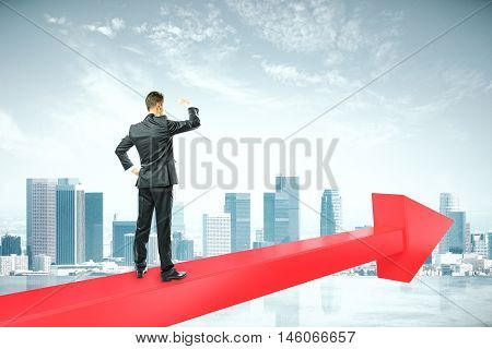Success concept with businessperson standing on red chart arrow and looking intor the distance on citybackground