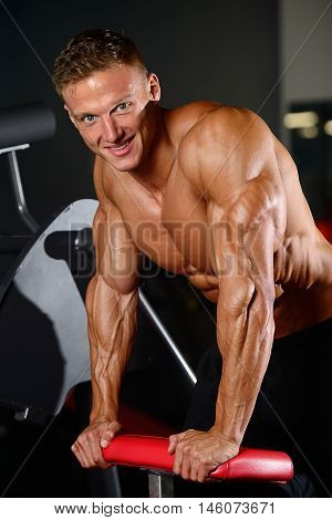 Handsome Muscular Bodybuilder Man Doing Exercises In Gym