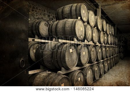 Wine barrels stacked in the old cellar of the winery.