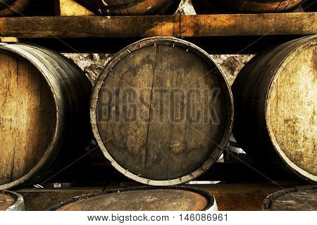 Wine barrels stacked in the old cellar of the winery.