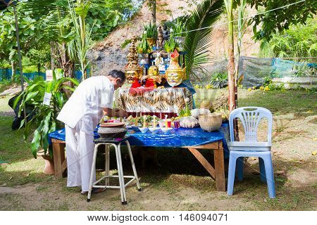 CHIANG RAI THAILAND - SEPTEMBER 1 : unidentified man in traditional white cloth ritualising in front of altar table on September 1 2016 in Chiang rai Thailand.