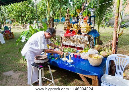 CHIANG RAI THAILAND - SEPTEMBER 1 : unidentified man in traditional white cloth ritualising in front of altar table on September 1 2016 in Chiang rai Thailand.
