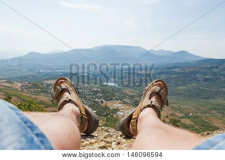 Men in sport sandals lies on the top of Demerdzhi mountain. Close up detail of male feet. Relax after climbing. Crimea Russia.