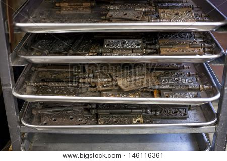 Tarnished hinges dry out on shelving in a bookbinders studio.