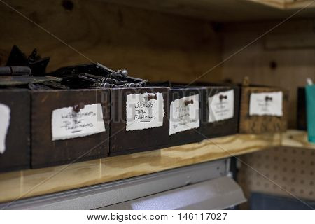 Labeled boxes sit on a shelf inside a bookbinders studio.