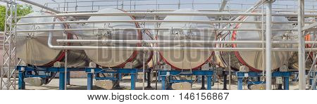 Panorama of a several stainless steel vessels and pipework and other equipment used for the production of wine in modern winery