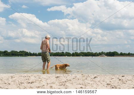 Senior Man With Dog In Water