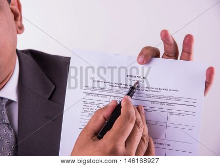 indian businessman showing indian income tax return form or ITR-4 form or form no. 16 of income tax department of india, selective focus