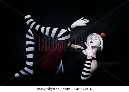 ตลก Mime ในหมวกสีขาวนอนอยู่บนพื้น