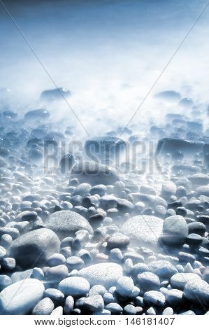 Background of water and rolling stones at Moelen