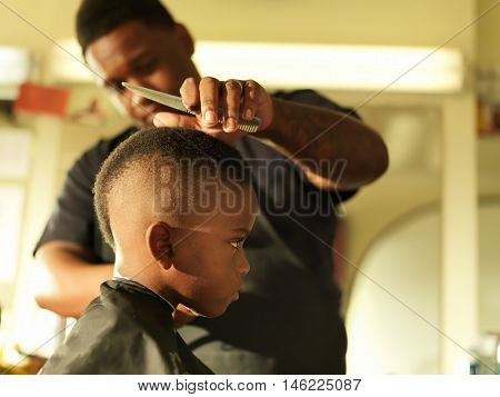little boy in barbershop getting head shaved