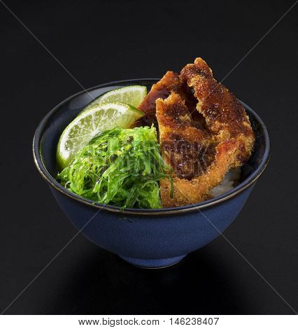 fried sea fish with fresh salad of seaweed lemons and cheese in a bowl