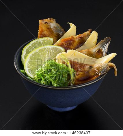 Roasted sea fish with fresh salad of seaweed lemons and cheese in a bowl