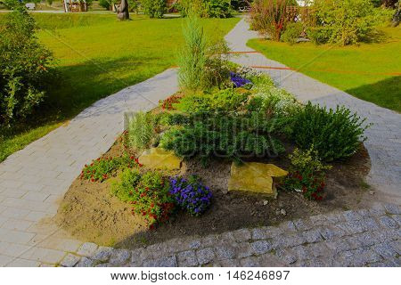 Flower beds surrounded by gardens and an alley near the house
