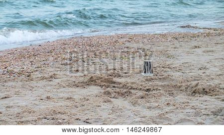 Coffee paper cup  on a sandy beach. Photo taken on the coast of the Azov Sea in August 2016.