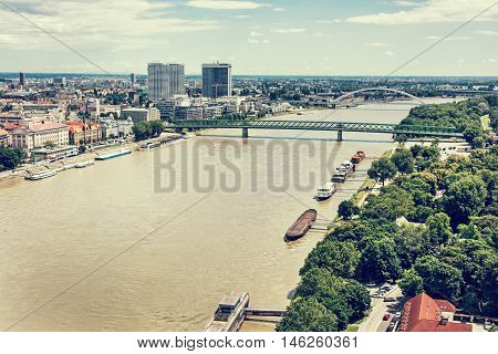 Bridges over the Danube river in Bratislava city Slovak republic. Docks scene. Old bridge and Apollo bridge. Ship transportation. Retro photo filter. Travel destination.
