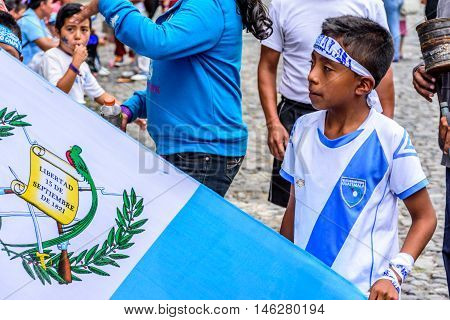Antigua Guatemala - September 14 2015: Locals wave Guatemalan flags & wear patriotic headbands & shirts during Guatemalan Independence Day celebrations