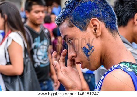 Antigua Guatemala - September 14 2015: Young patriot with blue hair & Guatemalan flag stamped on his face during Guatemalan Independence Day celebrations