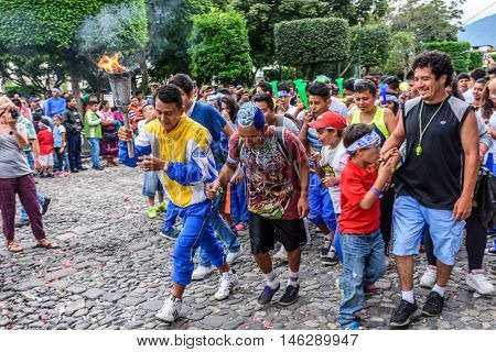 Antigua Guatemala - September 14 2015: Locals run in streets with lit torches while blowing whistles & horns during Guatemalan Independence Day celebrations