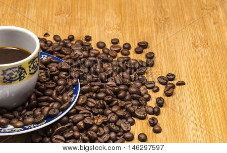 Coffee cup and coffee beans on a wooden table