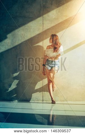 Fashion Portrait Of Young Model Posing By The Wall