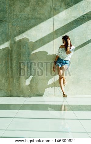 Fashion Portrait Of Young Model Posing By The Wall