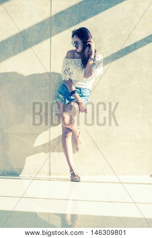 Fashion Portrait Of Young Model Posing By The Wall