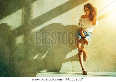 Fashion Portrait Of Young Model Posing By The Wall