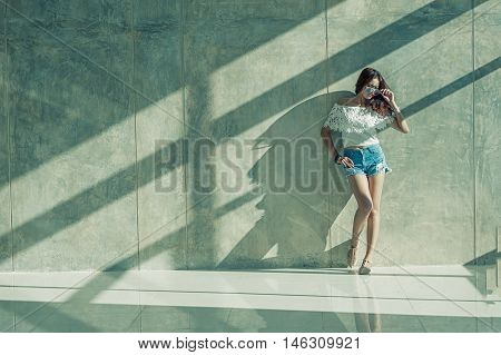Fashion Portrait Of Young Model Posing By The Wall