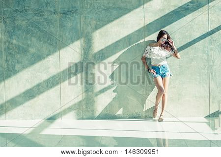 Fashion Portrait Of Young Model Posing By The Wall