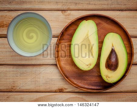 Fresh Avocado And Oil On Wooden Background. Organic Avocado Healthy Food Concept.