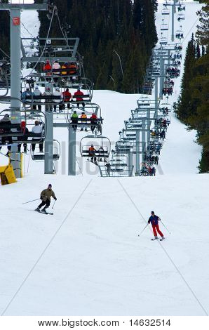 Stazione sciistica di neve molto occupato con quattro persona seggiovia