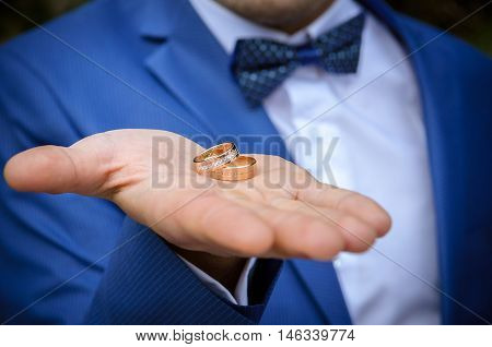 wedding rings on hand groom in blue jacket