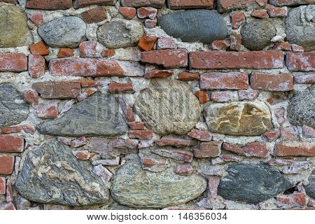 Brick and stone masonry in the old walls of a medieval castle. Texture of old brick wall background.