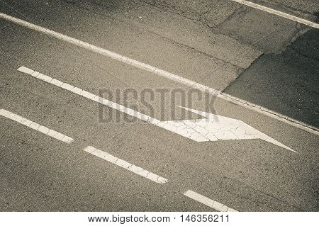 white arrow on the grey brake  road