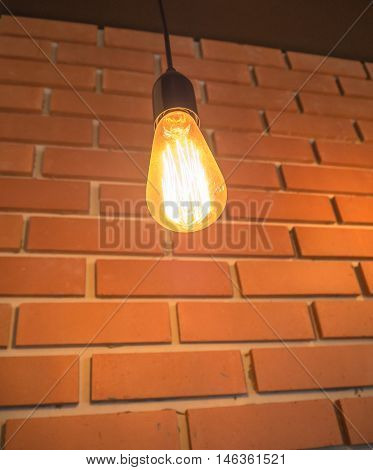Classic light bulb and brick wall background.