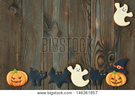Halloween homemade gingerbread cookies over wooden background