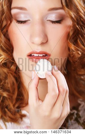 beauty portrait of a cute  girl in act to eat a candy with cocoanut