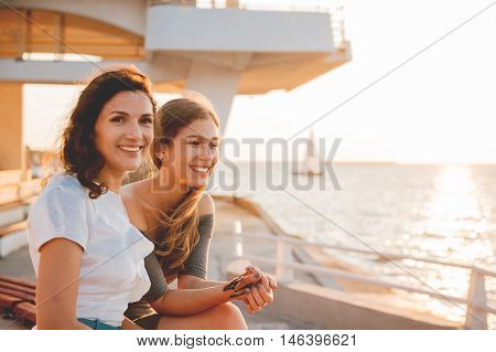 Close-up portrait of happy mother with teenage daughter. Sunset light.