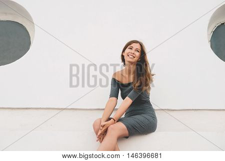 Portrait of cute and smiling teenage girl wearing casual gray dress.
