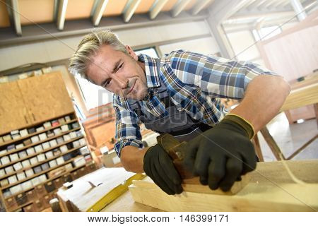 Carpenter working wood in workshop