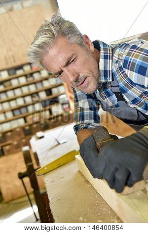 Carpenter working wood in workshop