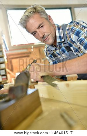 Carpenter working wood in workshop