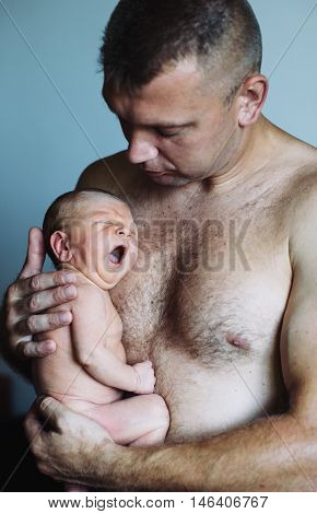 Father holding delicate his newborn baby boy