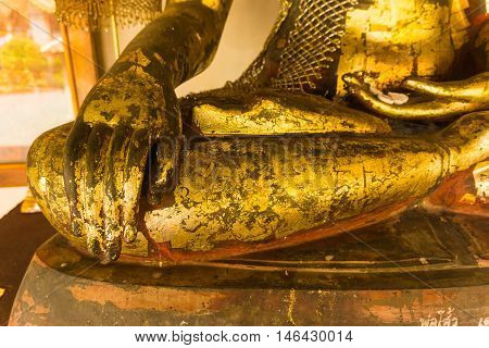 Close up hand of Buddha with gold stick plate