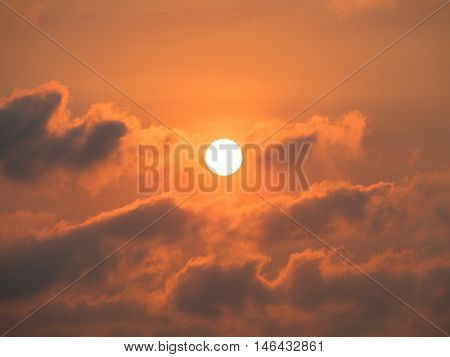 sunset with sun clouds over clouds. Spring scene. Dusk sky with sun hiding in clouds. Spring sunset