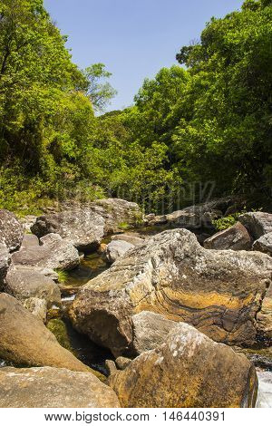 Water falls between rocks in sunny day.