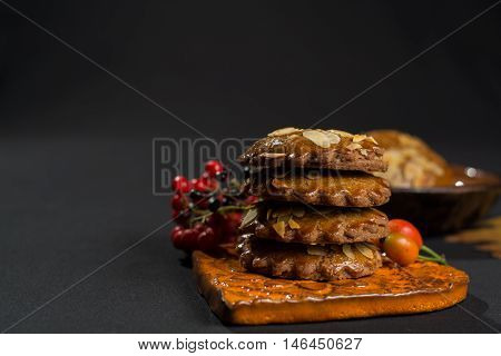 Typical Dutch filled spicy cookies with almonds on autumn colored and dark background