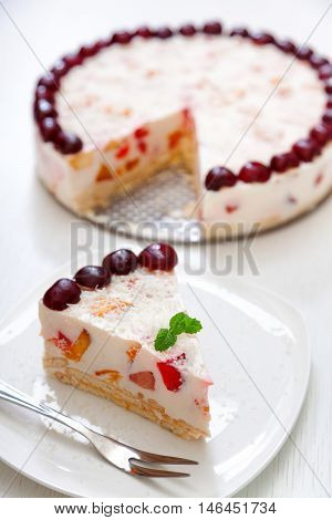 Cake with cherris gelly yogurt and fruits. Isolated on white background. One piece in a white plate. Vertical shot
